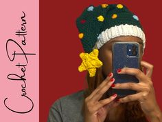 a woman taking a selfie with her cell phone wearing a knitted christmas hat