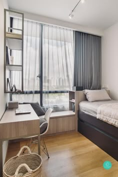 a bedroom with a bed, desk and window overlooking the cityscape is pictured in this image