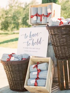 two baskets filled with blankets next to a sign that says to have and to hold in case you get cold