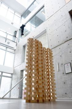 a tall wooden structure sitting in the middle of a room next to a stair case