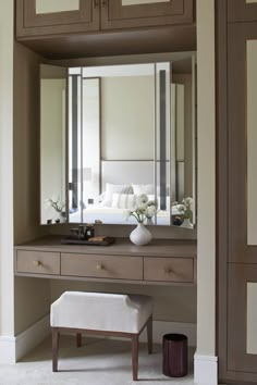 a dressing table with mirror, stool and flowers in the vase on it's side