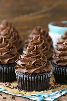 chocolate cupcakes with frosting and sprinkles on a blue plate