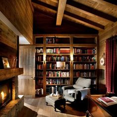 a living room filled with furniture and a fire place in front of a book shelf