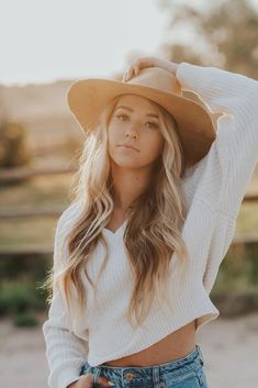 a woman with long hair wearing a hat