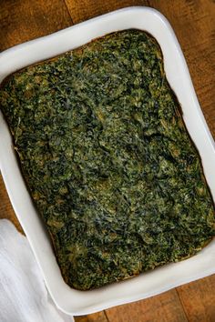 a square casserole dish filled with spinach