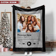 a christmas tree is next to a large black blanket with an image of four women on it