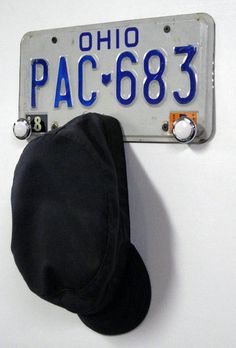 a hat is hanging on the wall next to a license plate that reads pac - 683