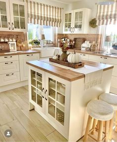 a kitchen filled with lots of white cabinets and counter top space next to a window