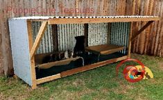 there are two cats sitting in the dog house made out of pallet boards and cardboard