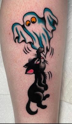 a black cat and ghost tattoo on the leg