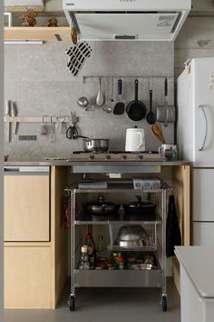 a kitchen with pots and pans hanging from the ceiling, on wheels in front of an oven