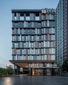 the entrance to an office building with many windows on each floor and two stories above it