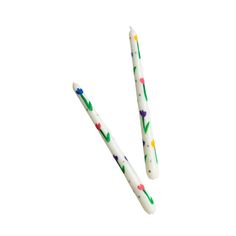 two white toothbrushes with colorful flowers on them