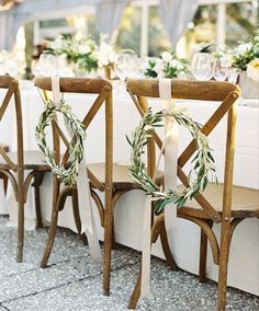 the chairs are lined up with wreaths on them