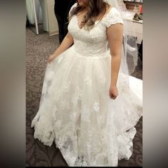 a woman in a wedding dress looking at her cell phone while she is getting ready to walk down the aisle