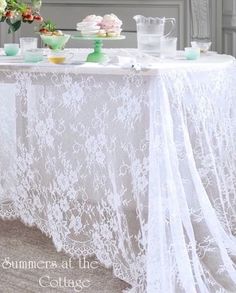 a white table with flowers and plates on it