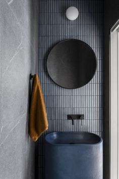 a blue bath tub sitting next to a round mirror