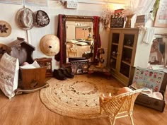 a living room filled with furniture and lots of clutter on top of a hard wood floor