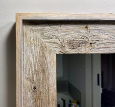 an old wooden mirror hanging on the wall