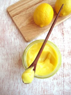 two lemons are sitting on a cutting board next to a jar of mayonnaise