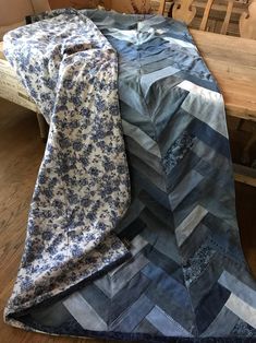 two pieces of blue and white quilt sitting on top of a wooden table