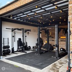 an indoor gym with equipment and lights on the side of the building, in front of a brick wall