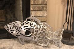 a fish sculpture sitting on top of a table next to a fireplace