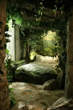 a bed sitting in the middle of a lush green forest filled with trees and plants