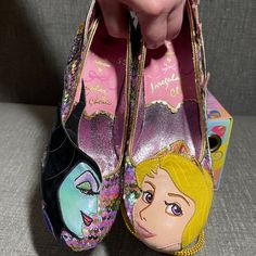 Irregular Choice X Disney's Sleeping Beauty Touch The Spindle! Heels. Limited Edition From The Disney Princess Collection. Pastel Rainbow Sequin Upper Mid-Heel. One Shoe Features Aurora Applique On The Toe With Pink Castle Applique On The Side, Pink And Blue Glitter And A Heel Made To Resemble Her Crown. The Other Shoe Features Maleficent Applique On The Toe, Her Raven Diablo On Her Staff On The Side Amid Purple Glitter Flames And A Heel With Even More Flame Applique. Gold Heel Cap. Cushioned Inner. Exclusive Printed Soles. Flame Applique, Disney Princess Collection, Irregular Choice Shoes, Pink Castle, Disney Sleeping Beauty, Irregular Choice, Princess Collection, Heel Caps, Gold Heels