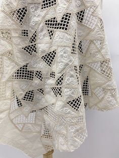 a white crocheted tablecloth on a wooden stand