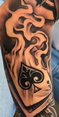 a man's arm with tattoos on it and flames coming out of the back