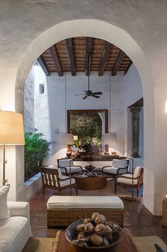 a living room filled with furniture and a ceiling fan in the middle of an archway