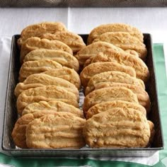 a pan filled with cookies sitting on top of a green and white tablecloth covered table