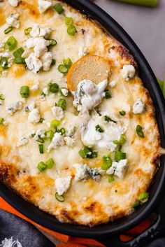 a cheesy casserole with peas and cheese in a black skillet