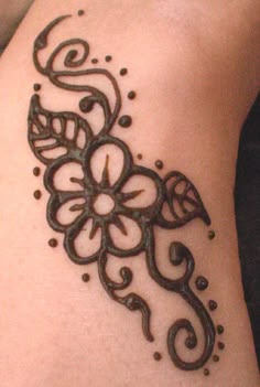 a tattoo on the side of a woman's leg with an intricate flower design