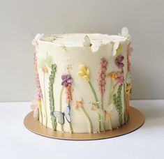 a white cake decorated with flowers and butterflies