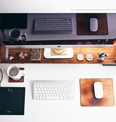 an overhead view of a desk with computer, keyboard, mouse and coffee cup on it