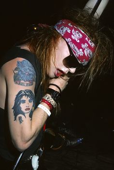 a man with long hair and tattoos on his arm