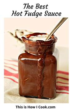 the best hot fudge sauce is in a glass jar with a spoon sticking out of it