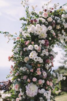 a bunch of white and pink flowers on a pole