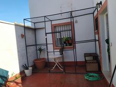 an outdoor patio with potted plants on the side and a door to another room