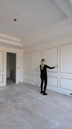 a woman is standing in an empty room