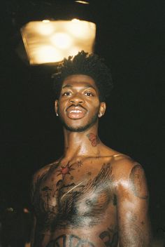 a shirtless man with tattoos on his chest