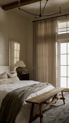 a bed sitting next to a window in a bedroom on top of a wooden table