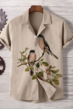 a shirt with two birds painted on the front and back, sitting on a wooden table