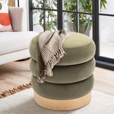 a living room filled with furniture and a large window covered in lots of natural greenery