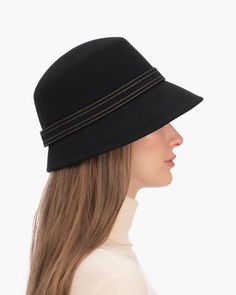 A fashionable women's cloche hat is hand-blocked of the finest superfelt, and then trimmed with a contrast stitch matching band of the same. The ultra sleek silhouette features a rakishly downturned brim, bringing focus to the eyes while framing the face beautifully. Brim span center front: 2.75"(7cm) side: 3"(7.5cm) Designed and finished in the USA Hand-blocked by skilled artisans Sustainable wool and cashmere blend superfelt Elasticized sweatband Adjustable head-size with hidden velcro® featur Elegant Black Bucket Hat, Adjustable Fur Felt Cloche Hat With Flat Brim, Fitted Fur Felt Cloche Hat With Flat Brim, Black Fur Felt Cloche Hat With Wide Brim, Black Fur Felt Wide Brim Cloche Hat, Black Wide Brim Cloche Hat In Fur Felt, Black Wide Brim Fur Felt Cloche Hat, Black Wool Cloche Hat, Fall Cloche Hat With Short Brim In Fur Felt