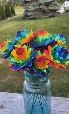 colorful paper flowers in a mason jar on a picnic table