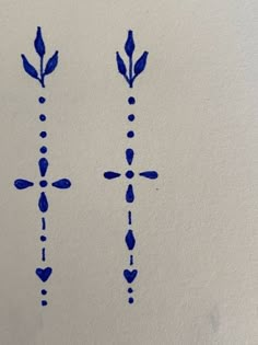 two blue crosses drawn on paper with ink in the shape of hearts and arrows,