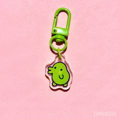 a green plastic keychain with a cartoon character on it's front end